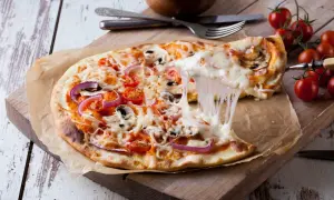 Rozciągający się ser z pizzy margherita z pomidorkami, cebulą i pieczarkami.