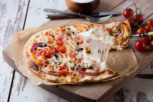 Rozciągający się ser z pizzy margherita z pomidorkami, cebulą i pieczarkami.
